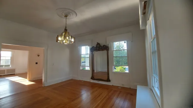 a view of empty room with wooden floor and fireplace