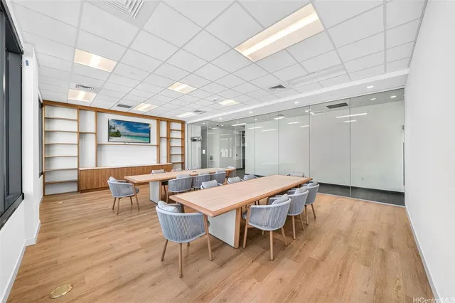 a dining hall with stainless steel appliances granite countertop a stove a sink a dining table and chairs with wooden floor