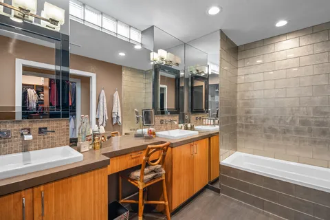 a bathroom with a sink a large mirror and a bathtub