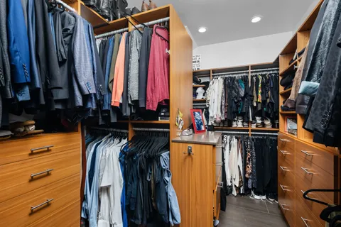 a view of walk in closet with clothes and shoes