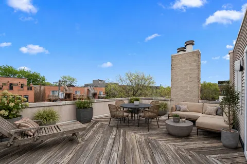 a view of a roof deck with couches and potted plants