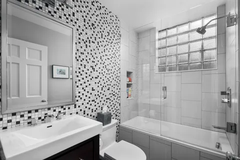 a bathroom with a bathtub sink mirror and toilet