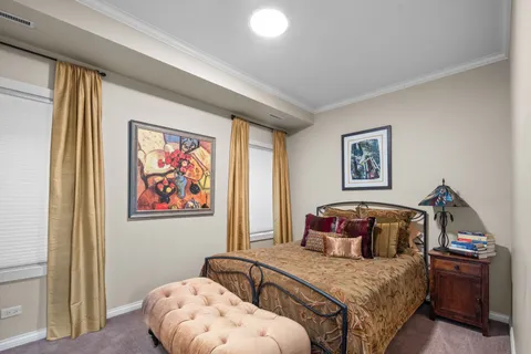 a bedroom with a bed and painting on the wall