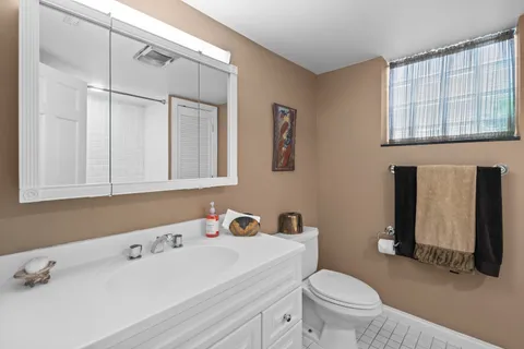 a bathroom with a sink a toilet and a mirror
