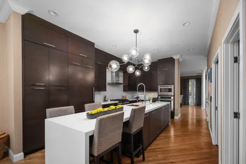 a kitchen with stainless steel appliances kitchen island granite countertop a sink a stove and refrigerator