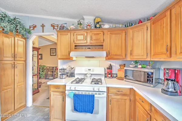 a kitchen with granite countertop a sink dishwasher stove and cabinets