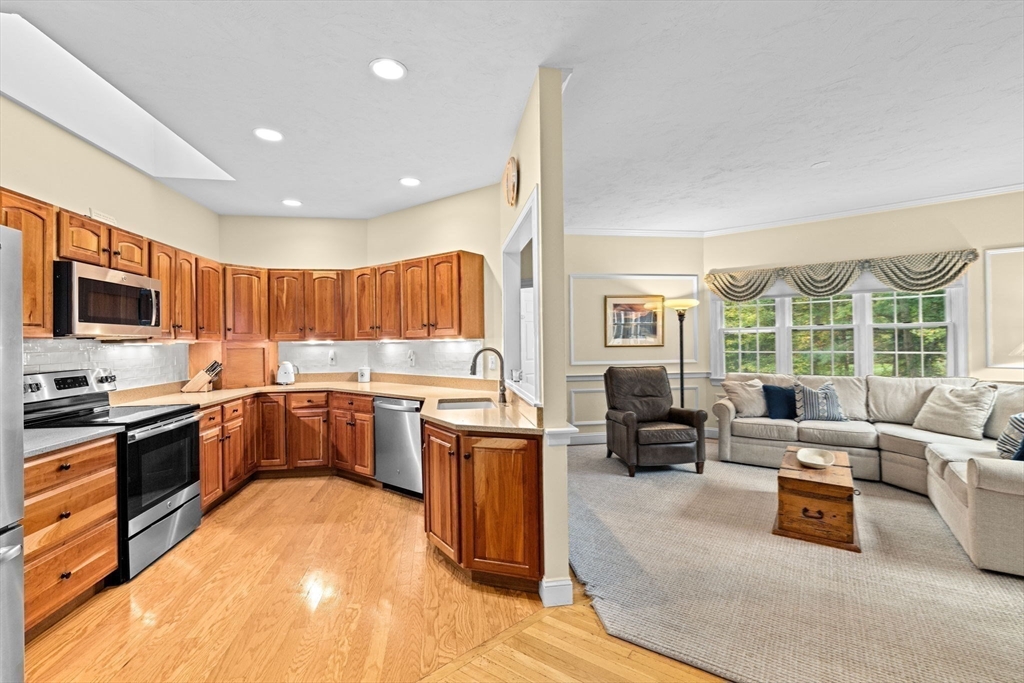 9 Forest Scituate Ma, Unit 9 Scituate, MA 02066 - Photo 8 of 35 a kitchen with stainless steel appliances granite countertop a stove top oven a sink dishwasher a dining table and chairs with wooden floor