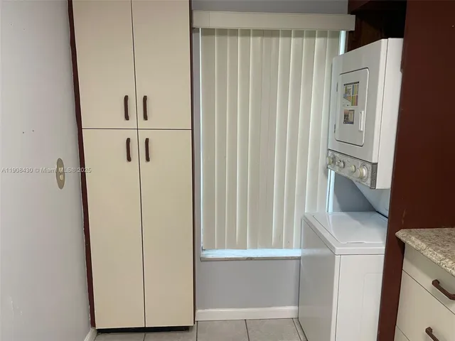 a view of walk in closet with white cabinet and door
