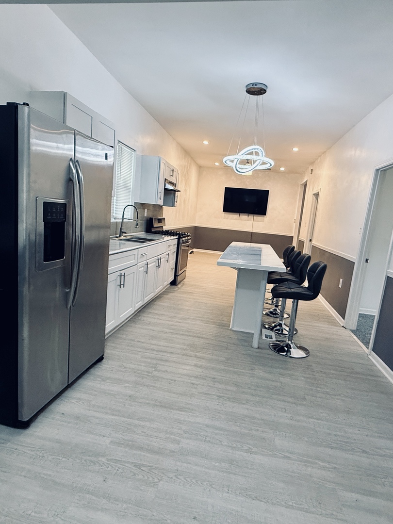 11725 South Morgan Street Chicago, IL 60643 - Photo 6 of 40 a kitchen with stainless steel appliances kitchen island granite countertop a refrigerator a stove a sink dishwasher and a dining table with wooden floor