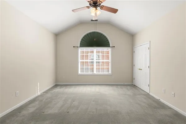 an empty room with a ceiling fan and window