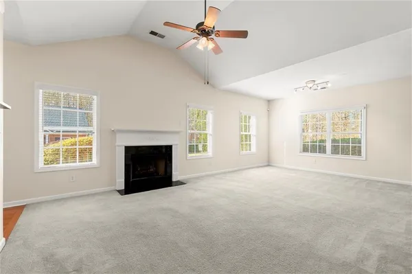an empty room with windows and fireplace