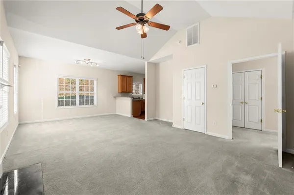 a view of a big room with windows and chandelier fan