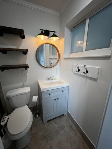 a bathroom with a toilet sink and mirror