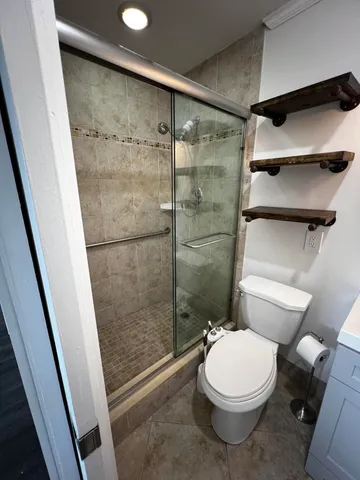 a bathroom with a toilet and a shower