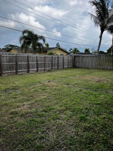 a view of a yard with wooden fence