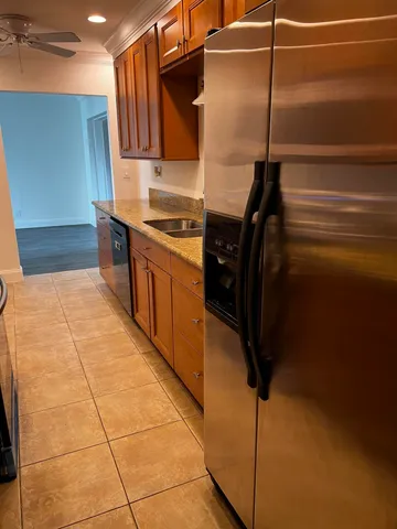 a kitchen with granite countertop a refrigerator and a stove top oven