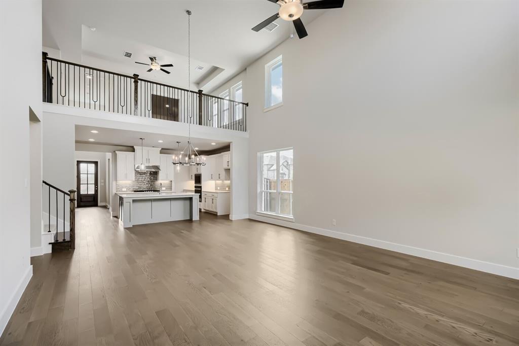 4407 Windy Point Road Oak Point, TX 75068 - Photo 4 of 27 Expansive living area with high ceilings, wood-finish flooring, and multiple windows