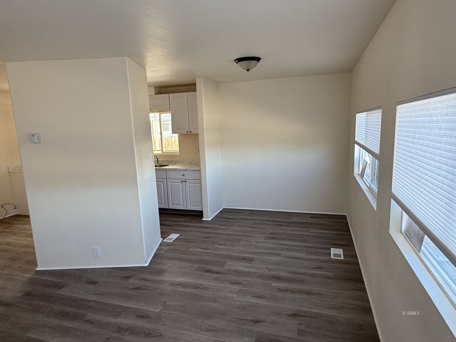1345 West Upjohn Avenue Ridgecrest, CA 93555 - Photo 2 of 9 an empty room with wooden floor and windows