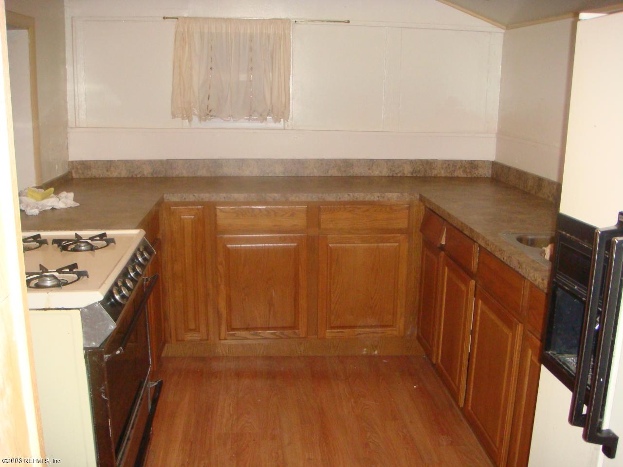 10703 Old Kings Road Jacksonville, FL 32219 - Photo 4 of 15 Laminate wood floors and gas stove