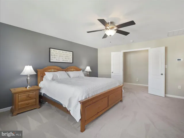 a bedroom with a large bed and dresser with mirror