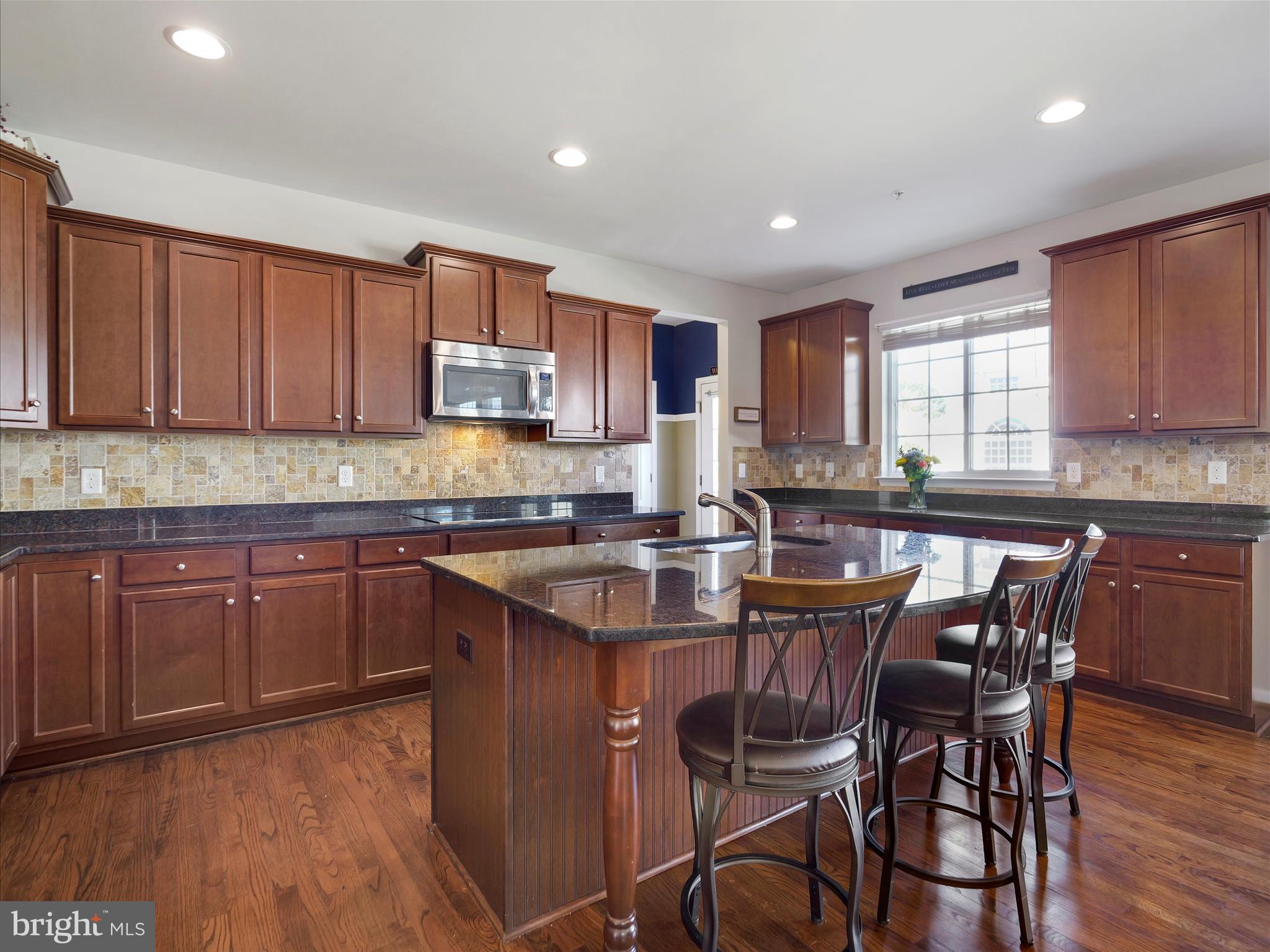 6200 Payton Way Frederick, MD 21703 - Photo 9 of 62 a kitchen with granite countertop wooden floors a center island and appliances