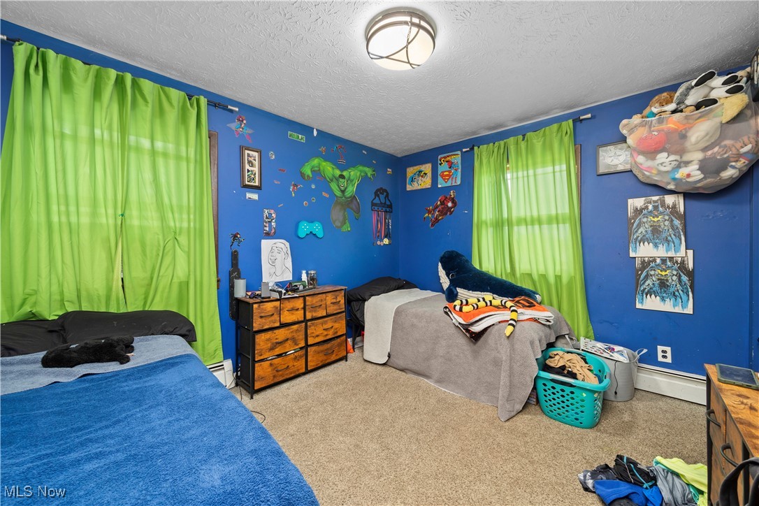8802 West Mason Road Castalia, OH 44824 - Photo 25 of 49 Carpeted bedroom with a textured ceiling and a baseboard heating unit