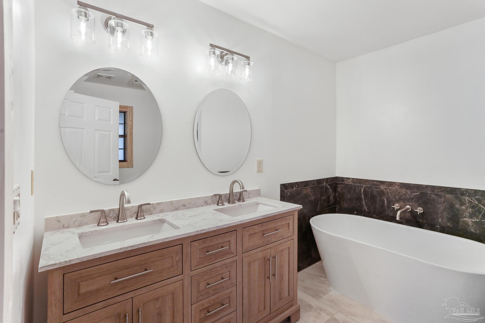6856 Martin Road Milton, FL 32570 - Photo 23 of 50 a bathroom with a double vanity sink and a mirror