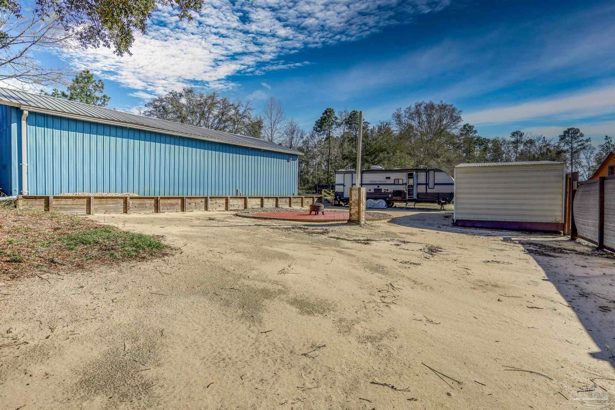 6856 Martin Road Milton, FL 32570 - Photo 40 of 50 a view of a backyard with a chair and table in the patio