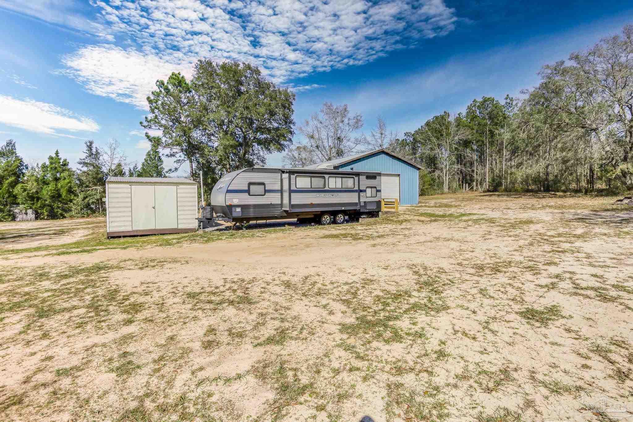 6856 Martin Road Milton, FL 32570 - Photo 42 of 50 a view of a house with a yard and trees