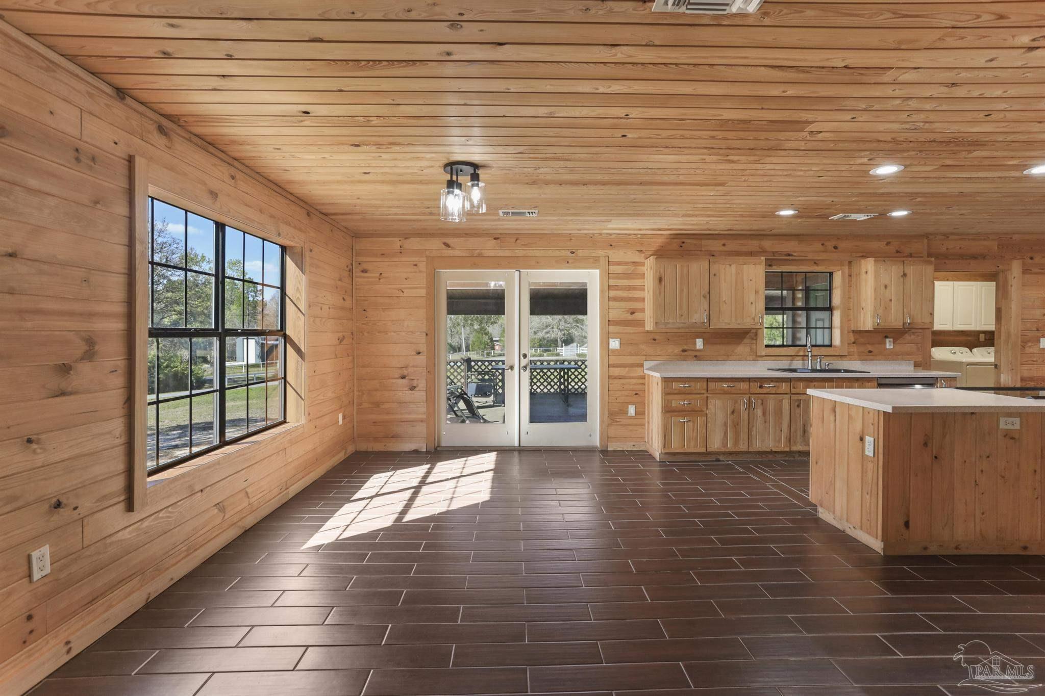 6856 Martin Road Milton, FL 32570 - Photo 9 of 50 a large white kitchen with kitchen island granite countertop a large window and a sink