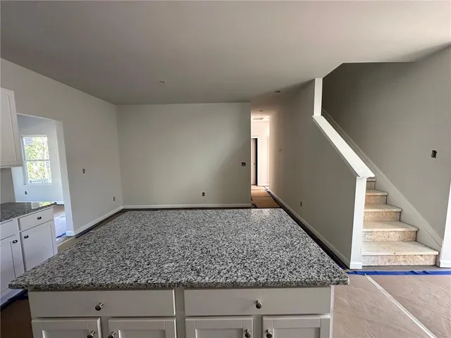 a bathroom with a granite countertop sink toilet and bathtub