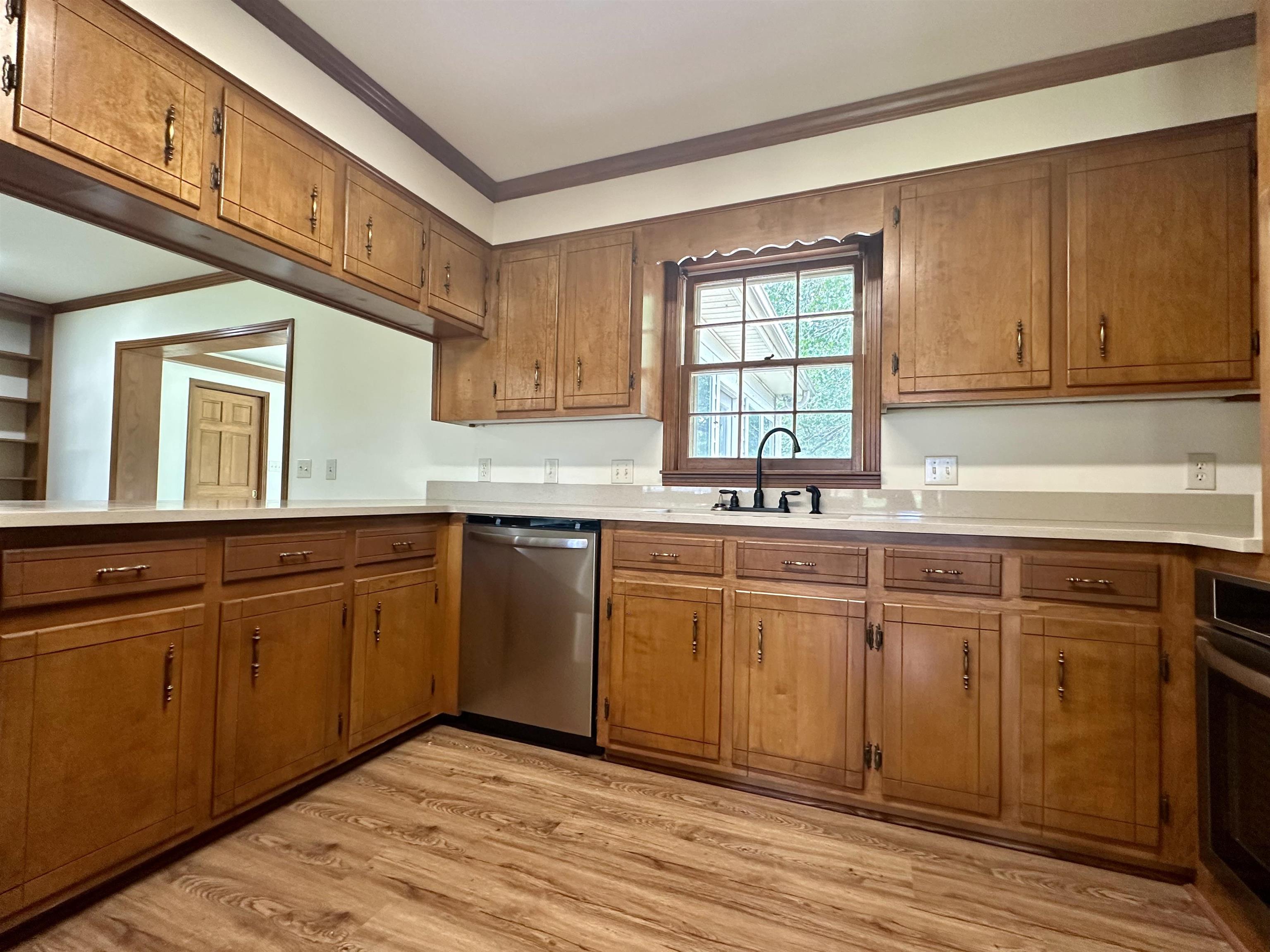 808 West Main Street Adamsville, TN 38310 - Photo 12 of 37 Kitchen featuring stainless steel appliances, brown cabinets, and ornamental molding
