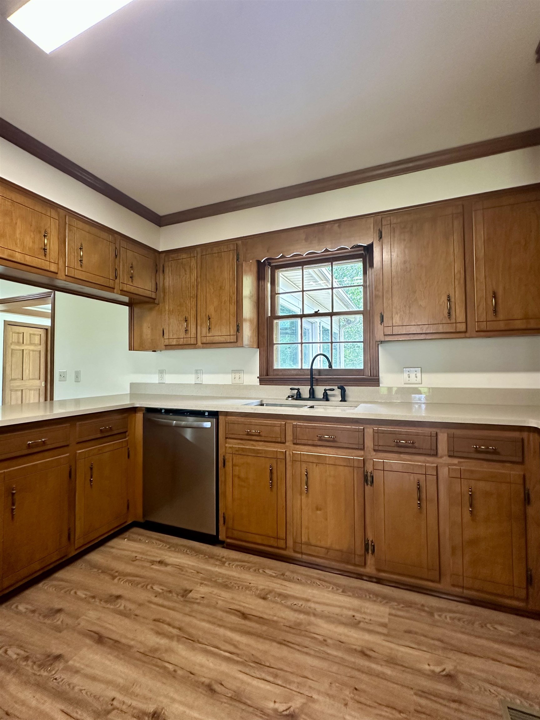 808 West Main Street Adamsville, TN 38310 - Photo 13 of 37 Kitchen featuring dishwasher, brown cabinets, light countertops, and crown molding
