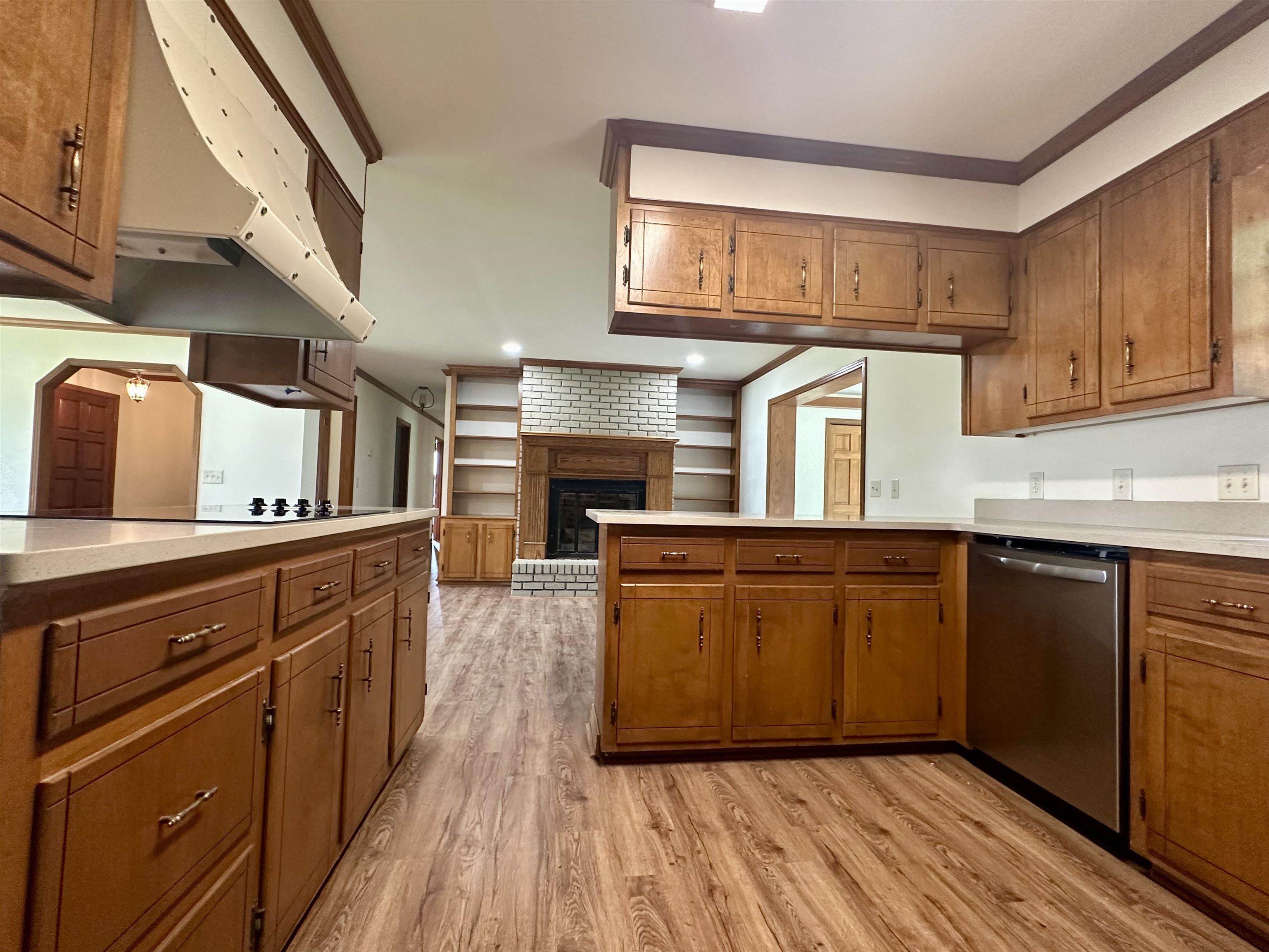 808 West Main Street Adamsville, TN 38310 - Photo 14 of 37 Kitchen featuring dishwasher, ventilation hood, light wood-style flooring, brown cabinets, and ornamental molding