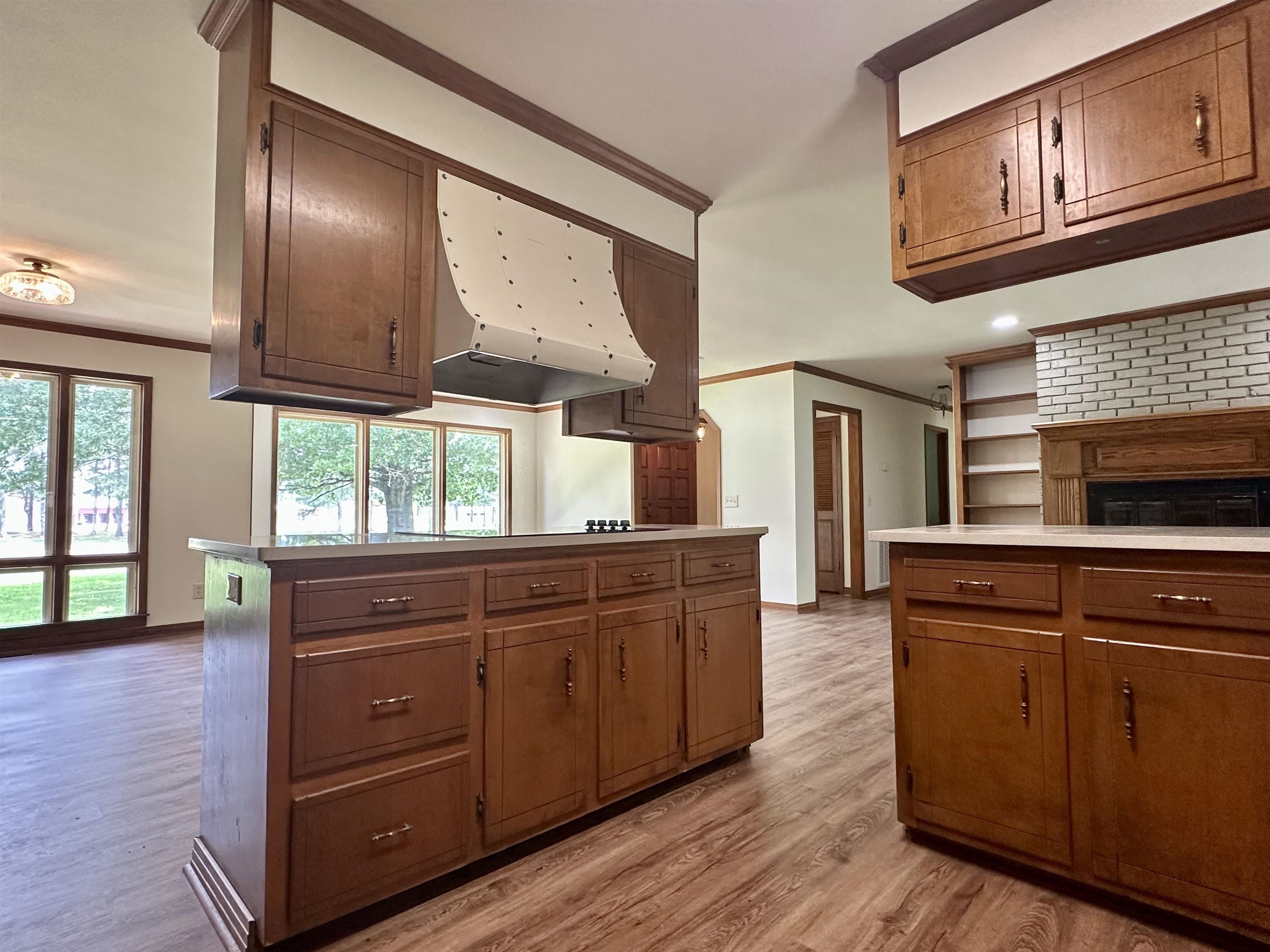 808 West Main Street Adamsville, TN 38310 - Photo 15 of 37 Kitchen with ornamental molding, light wood-style flooring, exhaust hood, and light countertops
