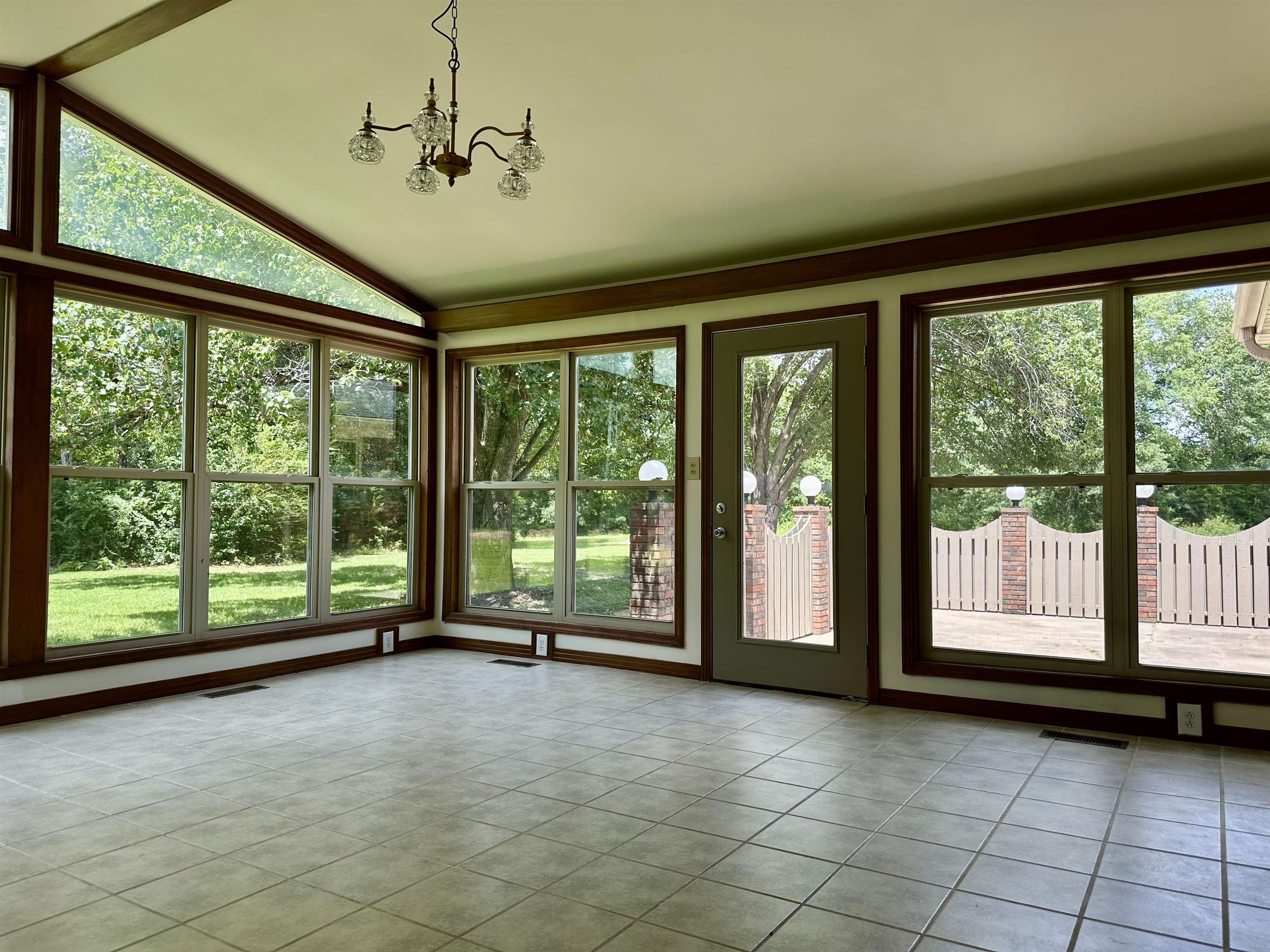 808 West Main Street Adamsville, TN 38310 - Photo 20 of 37 Unfurnished sunroom with vaulted ceiling, tile patterned floors, and a chandelier