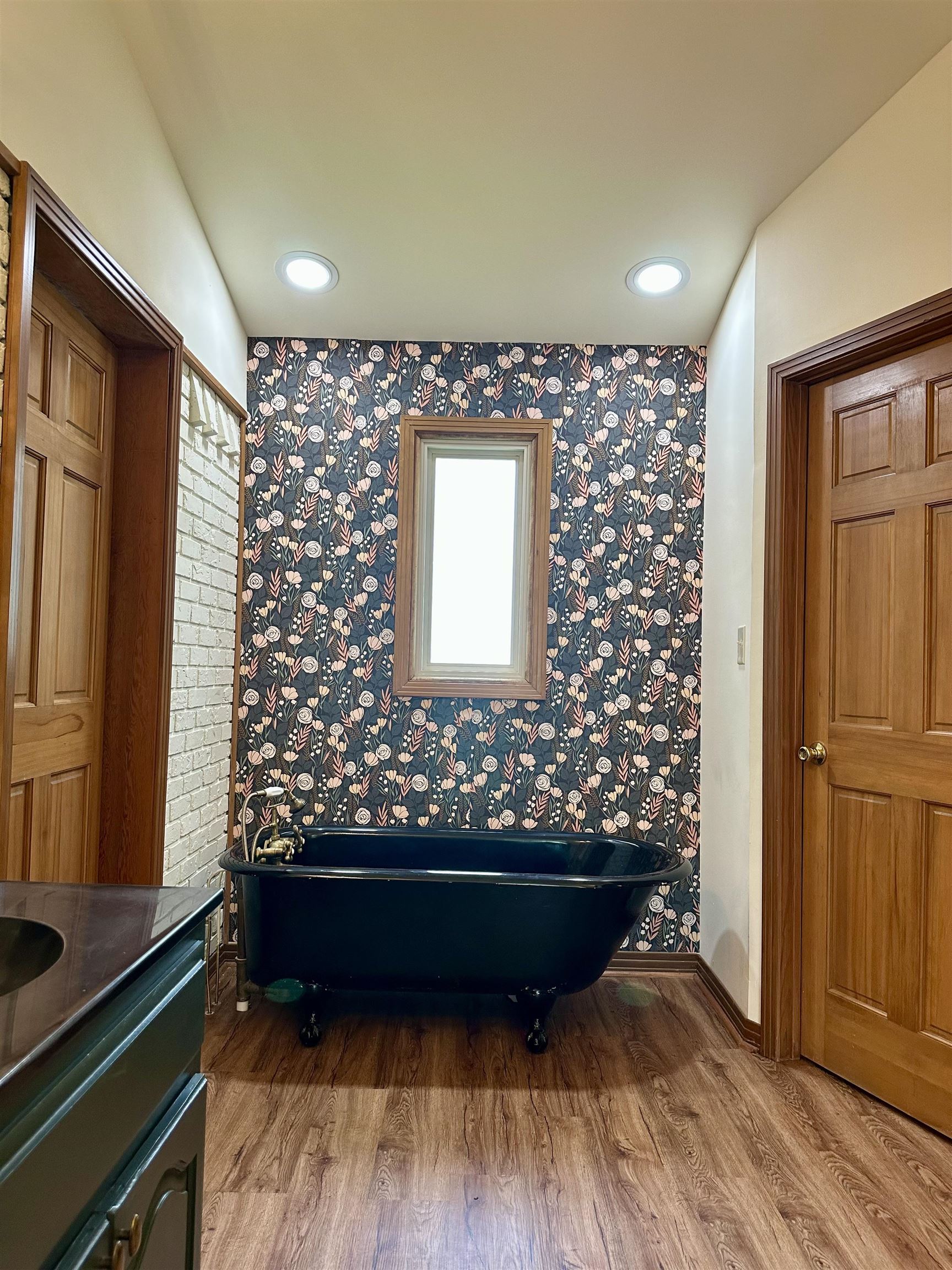 808 West Main Street Adamsville, TN 38310 - Photo 25 of 37 Full bathroom with wood finished floors, a freestanding tub, vanity, and wallpapered walls