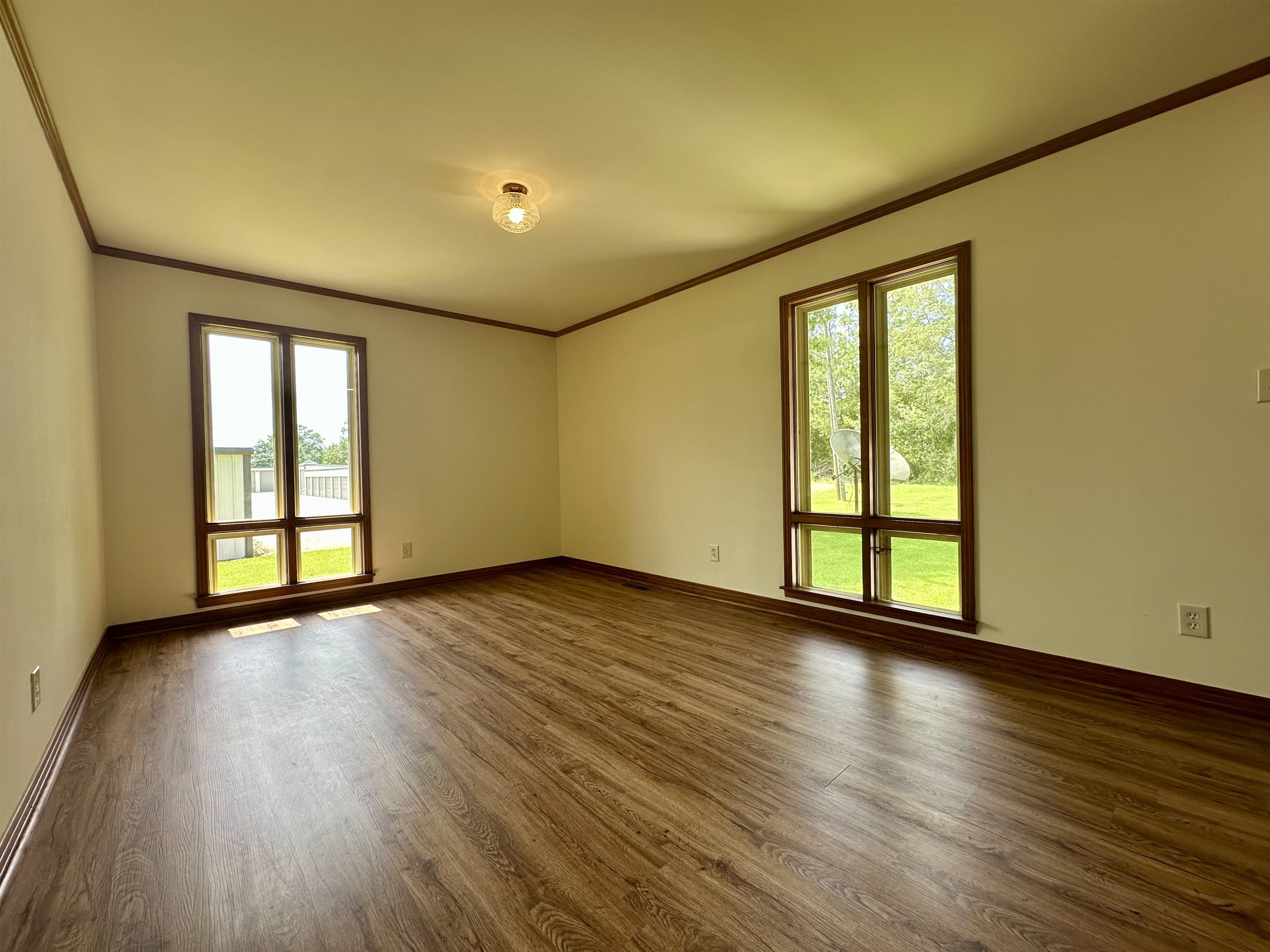 808 West Main Street Adamsville, TN 38310 - Photo 29 of 37 Empty room featuring ornamental molding, healthy amount of natural light, and dark wood-type flooring