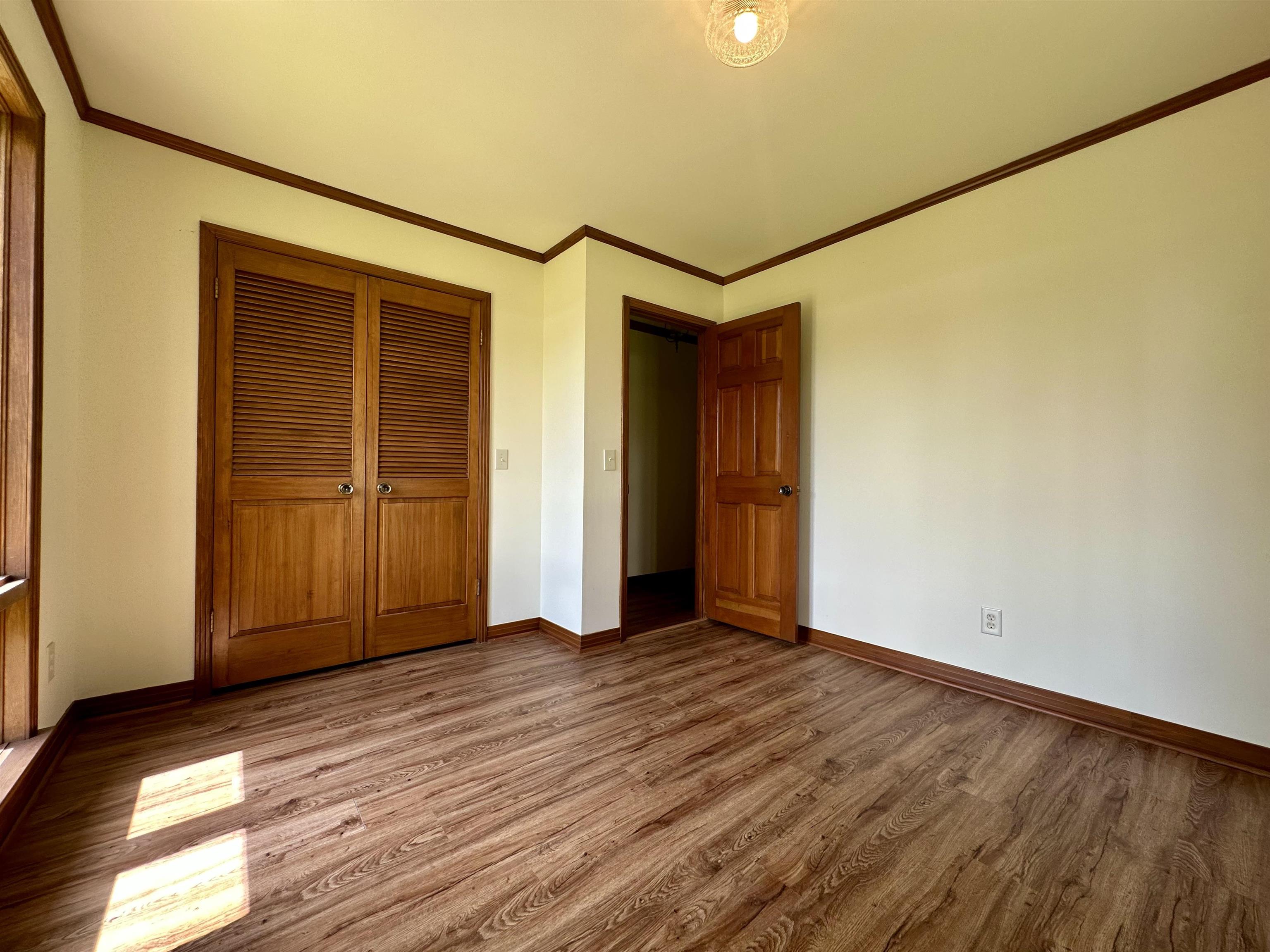 808 West Main Street Adamsville, TN 38310 - Photo 32 of 37 Unfurnished bedroom with wood finished floors, a closet, and ornamental molding