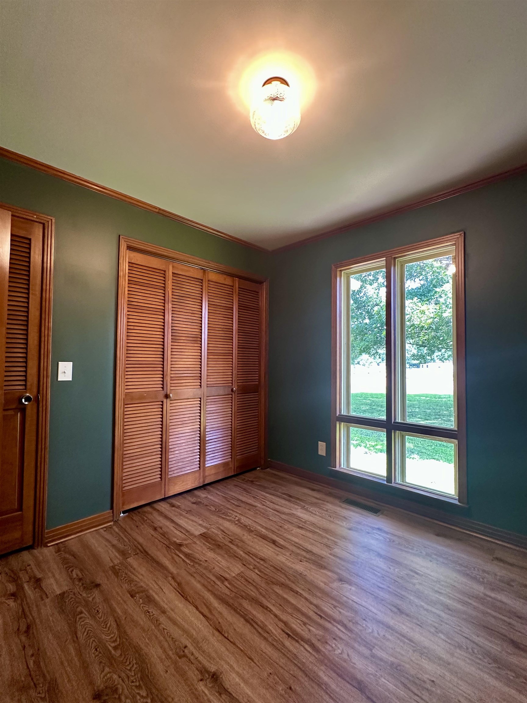 808 West Main Street Adamsville, TN 38310 - Photo 34 of 37 Unfurnished bedroom featuring wood finished floors, a closet, and crown molding