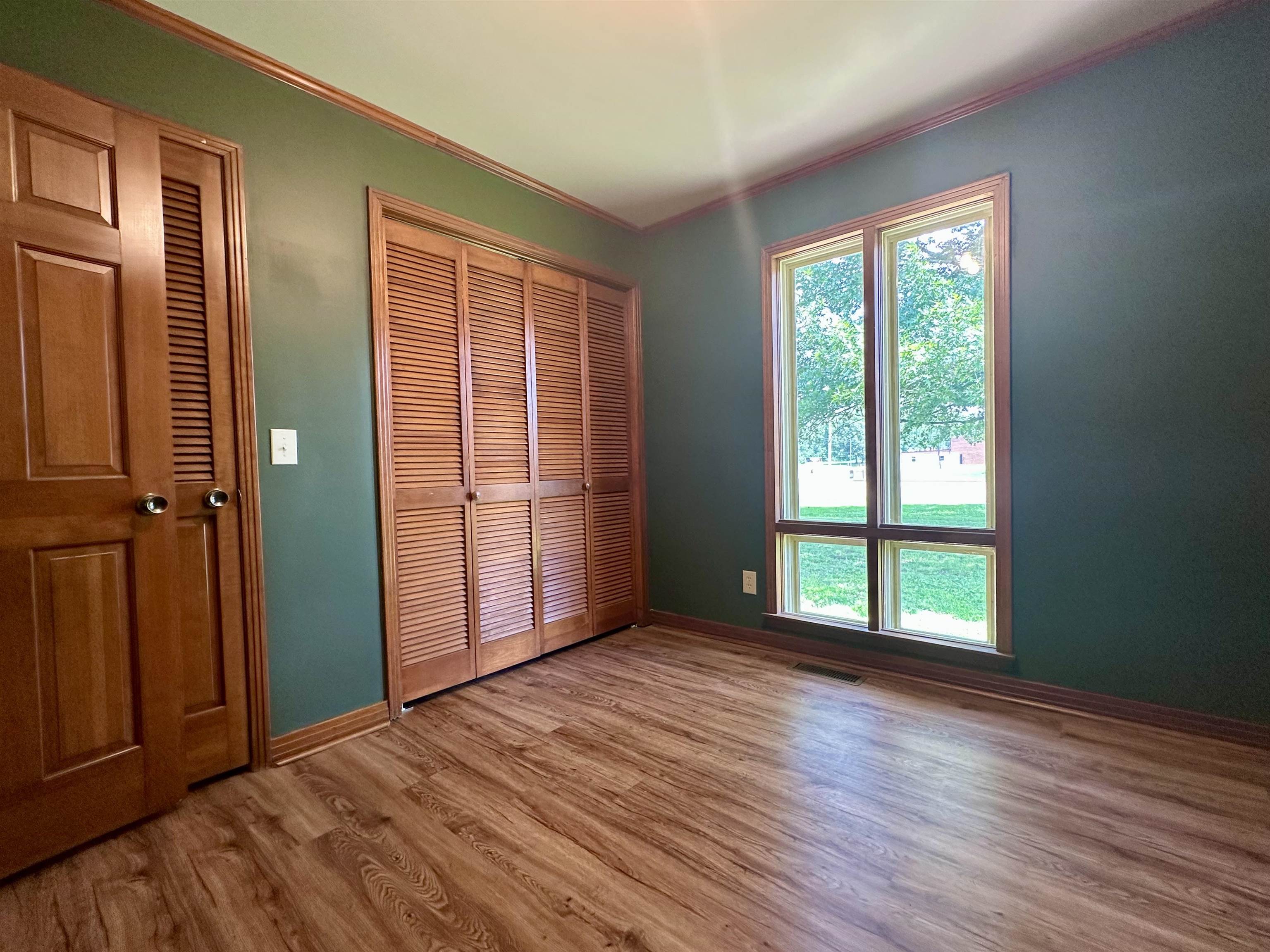 808 West Main Street Adamsville, TN 38310 - Photo 35 of 37 Unfurnished bedroom with ornamental molding, multiple windows, light wood-type flooring, and a closet