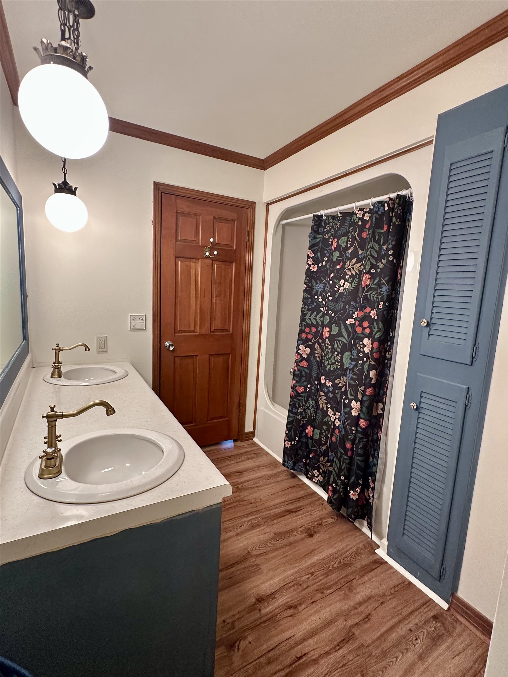 808 West Main Street Adamsville, TN 38310 - Photo 36 of 37 Bathroom featuring wood finished floors, ornamental molding, a shower with curtain, and double vanity