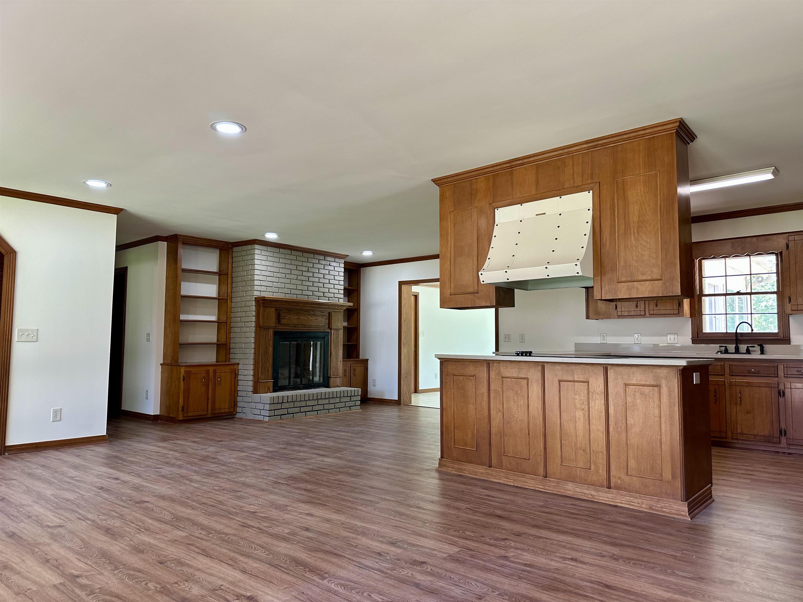 808 West Main Street Adamsville, TN 38310 - Photo 37 of 37 Kitchen featuring ornamental molding, dark wood-style flooring, exhaust hood, open floor plan, and light countertops