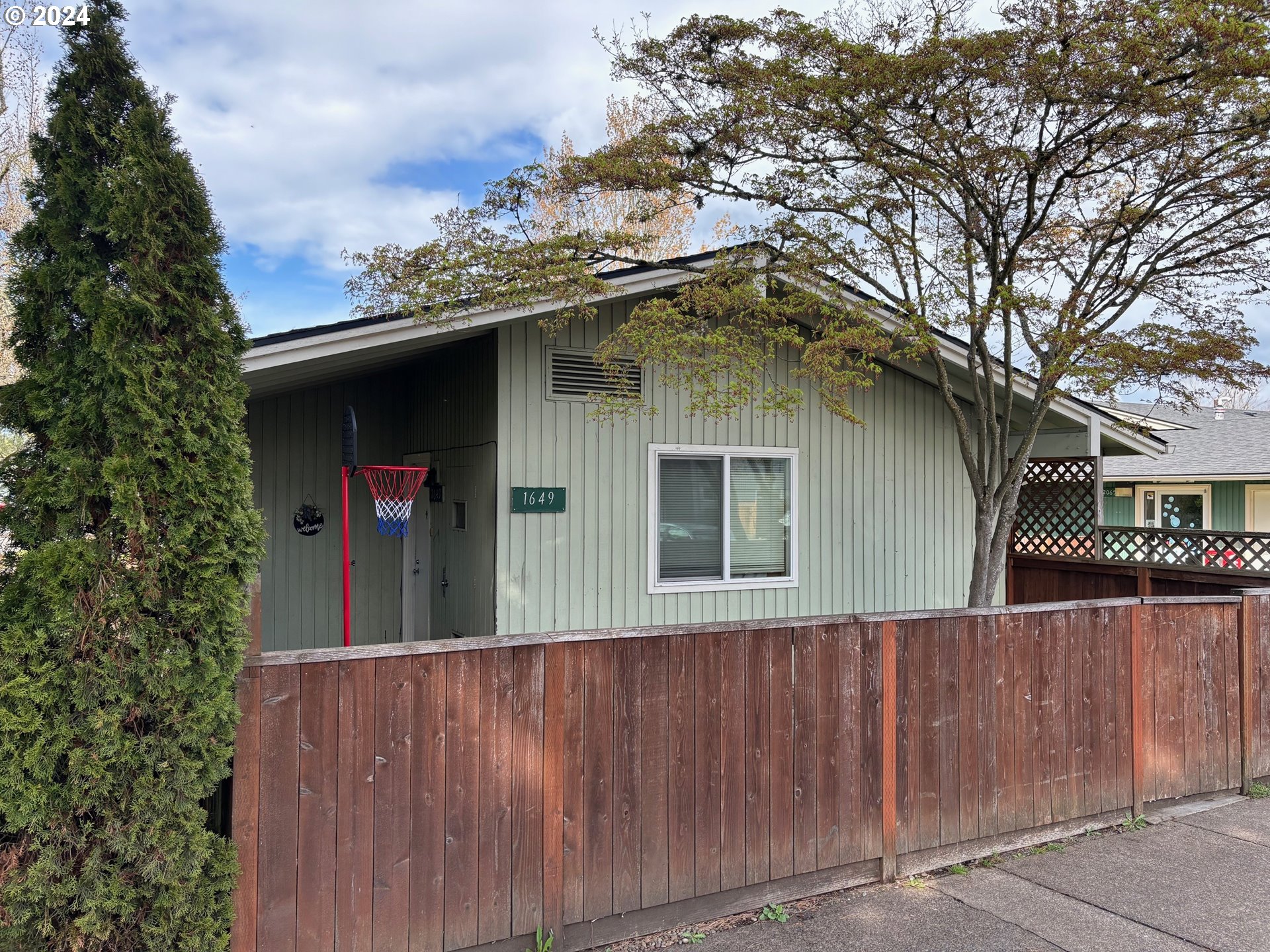 a front view of a house with a tree