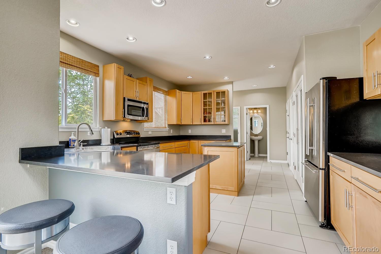 10750 Riverbrook Circle Highlands Ranch, CO 80126 - Photo 13 of 28 a large kitchen with stainless steel appliances granite countertop a sink a stove a dining table and chairs