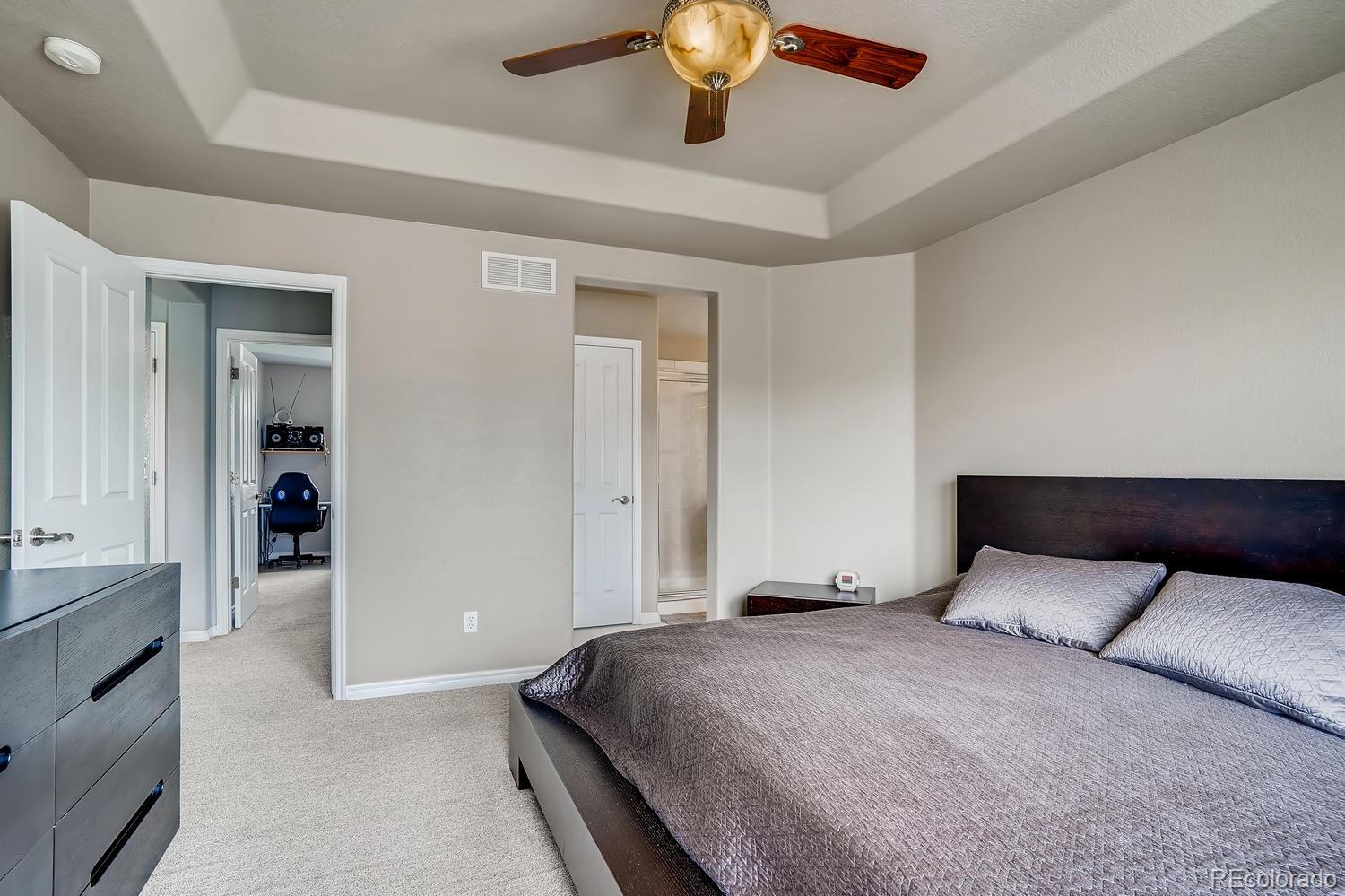 10750 Riverbrook Circle Highlands Ranch, CO 80126 - Photo 16 of 28 a bedroom with a large bed and ceiling fan