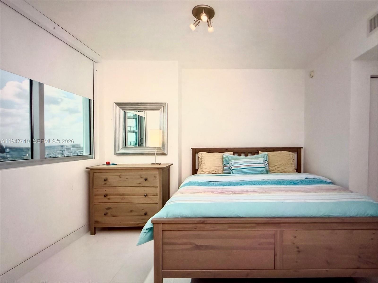 92 Southwest 3rd Street, Unit 4709 Miami, FL 33130 - Photo 11 of 18 a bedroom with a bed and a dresser