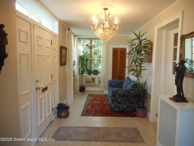 a view of a hallway to a livingroom with furniture and floor to ceiling window