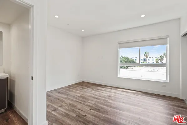 an empty room with wooden floor and a window