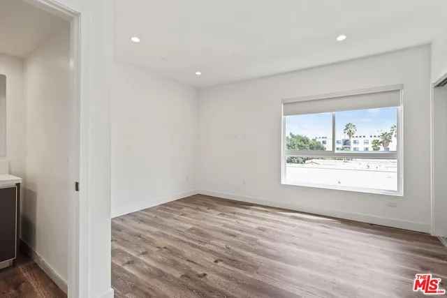 an empty room with wooden floor and a window